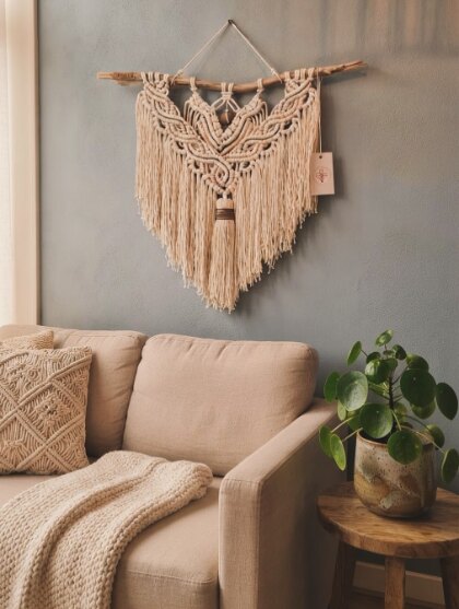 Painel de macramé em tons naturais decorando uma sala